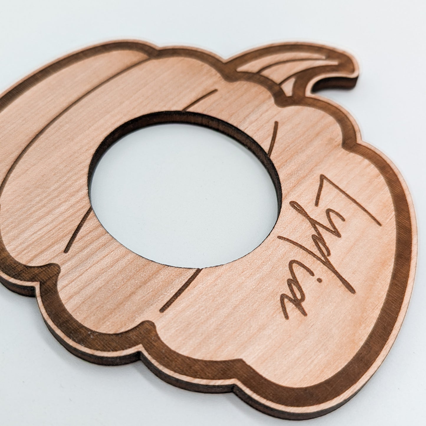 flat wooden pumpkin napkin rings engraved with names in a script font