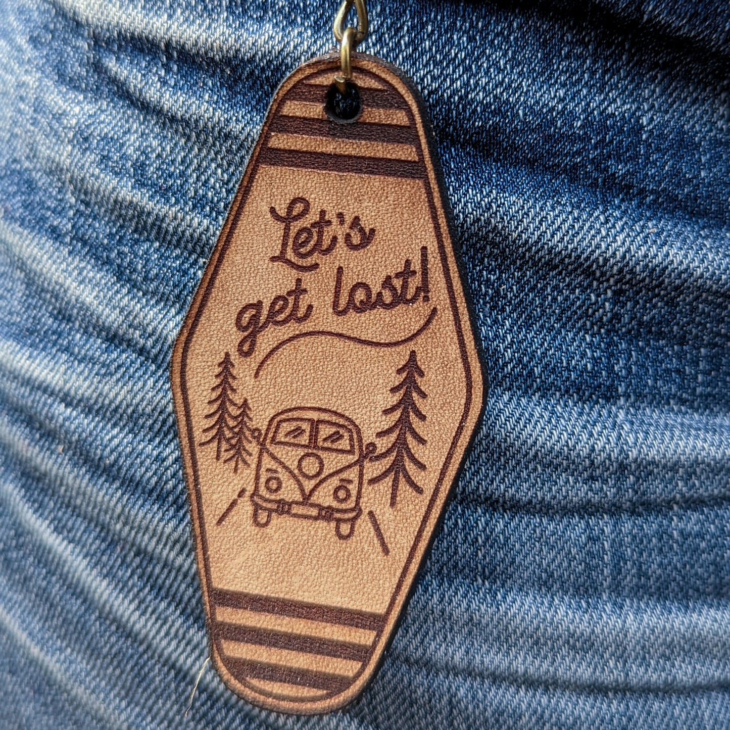 Leather Keychain cut and engraved to look like a vintage motel key with Let's get lost! and an illustration of a retro van on the road engraved on it.