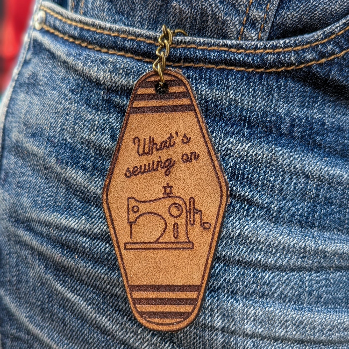 Leather Keychain cut and engraved to look like a vintage motel key whats sewing on and an line illustration of a sewing machine engraved on it.